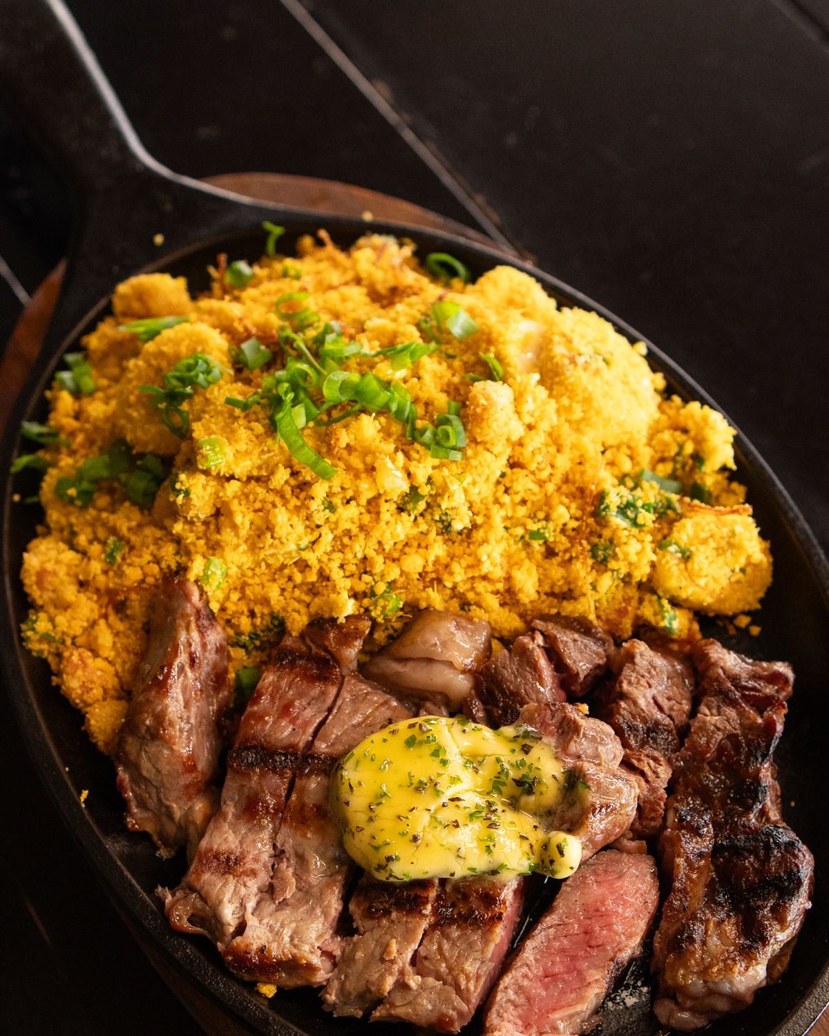 Bife ancho fatiado na chapa quente com manteiga de ervas e farofa